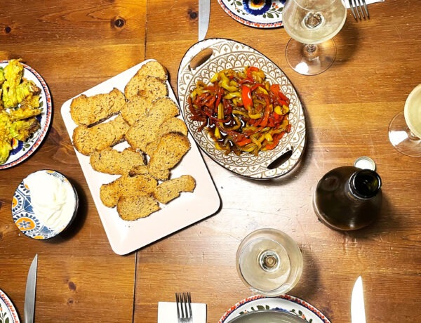 Antipasti mit Paprika, Frischkäse und Brot auf einem Tisch